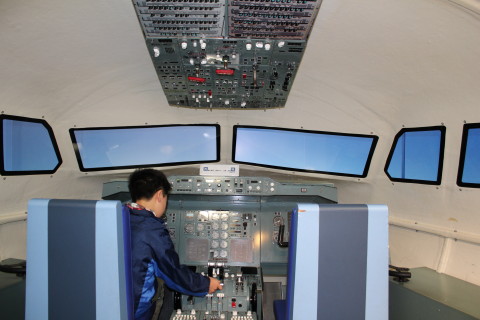 飛行機の操縦席を再現した展示物で遊ぶ息子