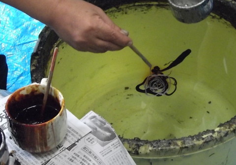 職人さんが塗料を水の上に垂らす