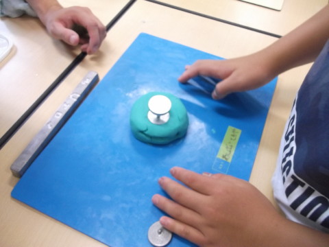 粘土に型を入れてベーゴマ作りの土台作り