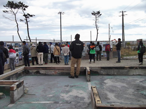 あらはま里浜ロッジで震災のパネルを見る人々