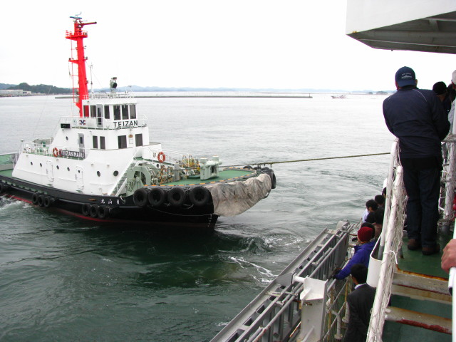 タグボート「貞山丸」に引かれて巡視船ざおうが離岸していく
