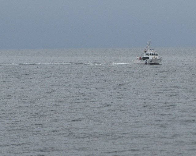 溺者救助訓練の準備をするため海に人をおろしている