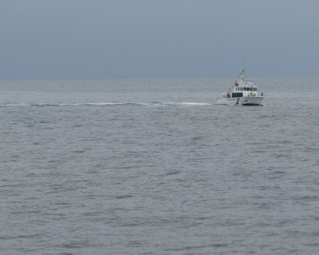溺者救助訓練の準備をするため海に人をおろしている